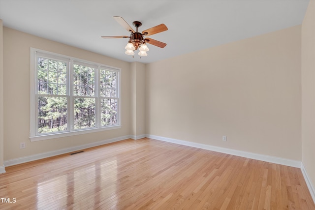 empty room featuring visible vents, baseboards, light wood-style floors, and a ceiling fan