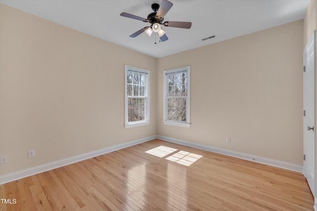 unfurnished room with a ceiling fan, visible vents, baseboards, and light wood-type flooring