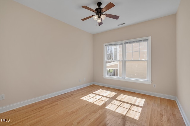 spare room featuring visible vents, light wood-style flooring, baseboards, and ceiling fan