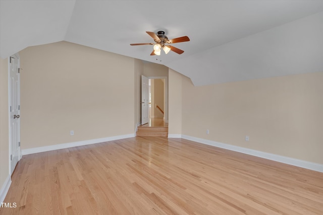 unfurnished room with light wood-type flooring, lofted ceiling, baseboards, and a ceiling fan