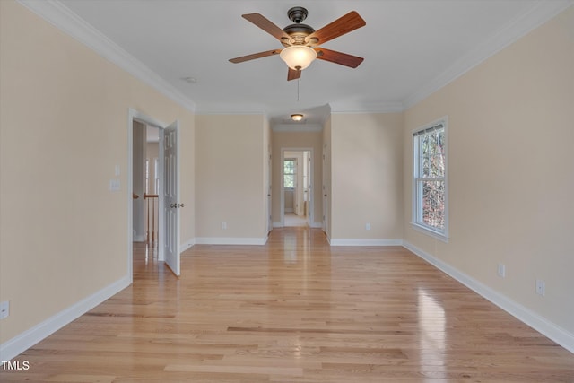 empty room featuring baseboards, light wood-style floors, a ceiling fan, and crown molding