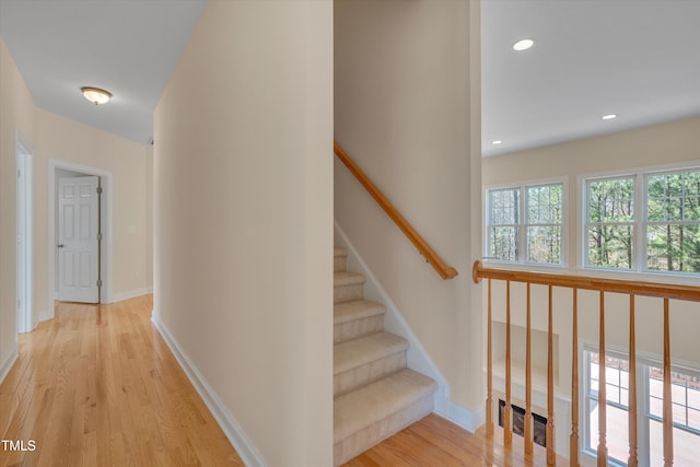 stairway with recessed lighting, wood finished floors, and baseboards