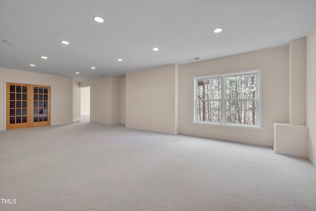 empty room featuring visible vents, baseboards, light carpet, recessed lighting, and french doors