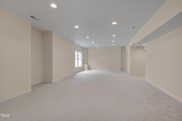 empty room with light colored carpet, recessed lighting, visible vents, and baseboards