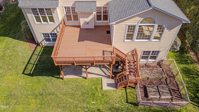 rear view of house with a yard, stairway, a deck, and roof with shingles