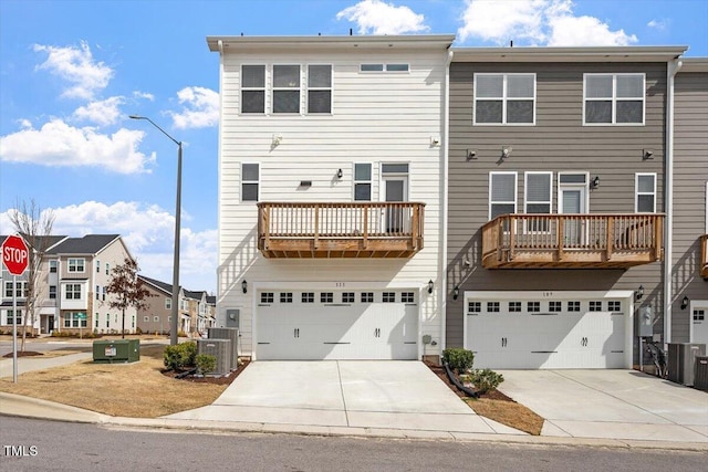 exterior space featuring a garage, cooling unit, and concrete driveway