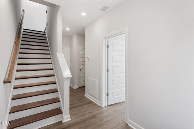 stairs featuring recessed lighting, visible vents, baseboards, and wood finished floors