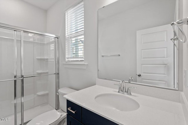 bathroom featuring a stall shower, vanity, and toilet