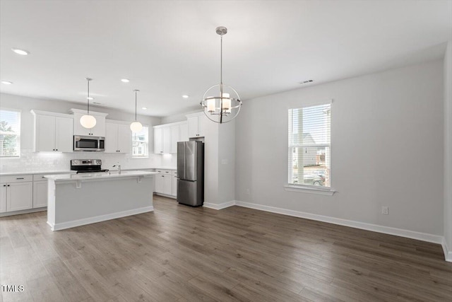 kitchen with appliances with stainless steel finishes, dark wood-style flooring, light countertops, and white cabinetry