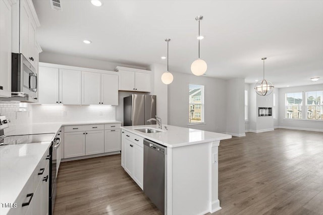 kitchen with tasteful backsplash, visible vents, appliances with stainless steel finishes, light wood-type flooring, and a sink