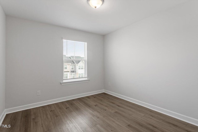 empty room with baseboards and dark wood-style flooring