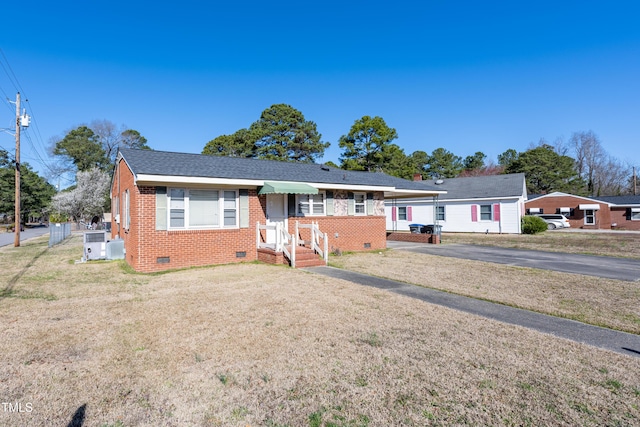 single story home with crawl space, brick siding, roof with shingles, and a front yard