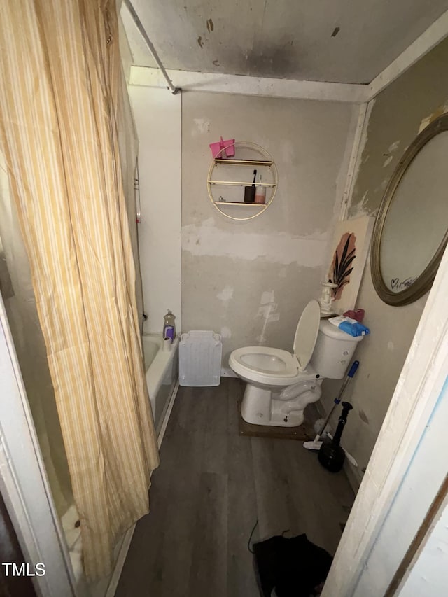 bathroom with toilet, shower / bath combo, and wood finished floors