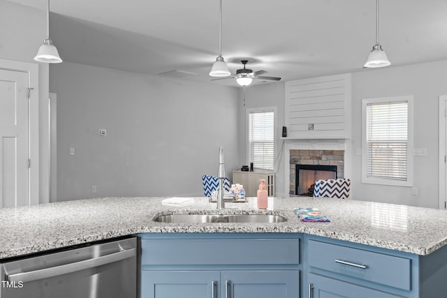 kitchen with a fireplace, a sink, open floor plan, blue cabinetry, and dishwasher