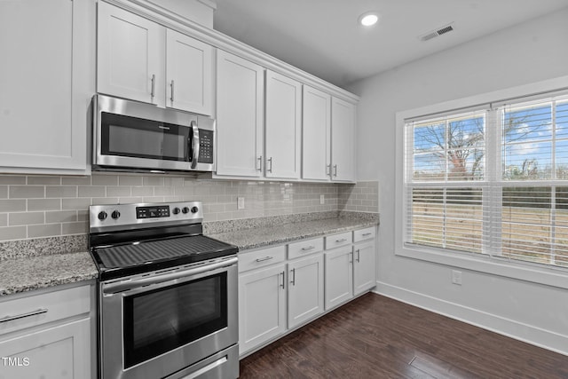 kitchen with stainless steel appliances, tasteful backsplash, visible vents, dark wood-type flooring, and baseboards