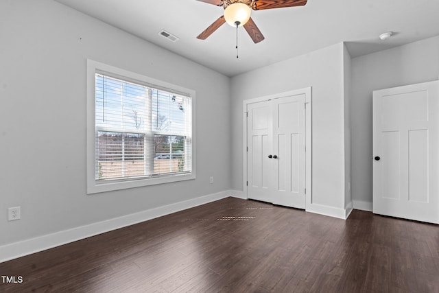 unfurnished bedroom with baseboards, visible vents, and dark wood finished floors