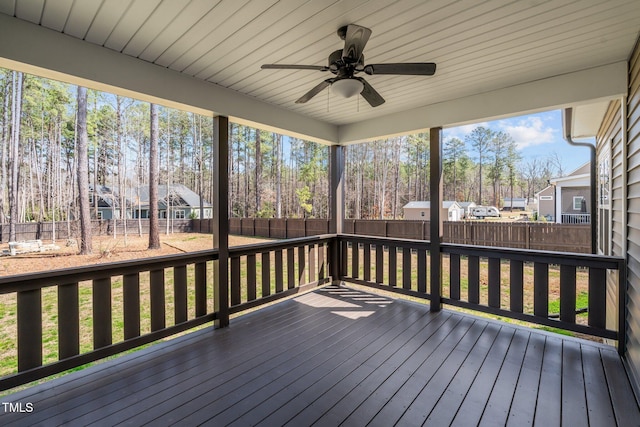 wooden terrace with a residential view, fence, and a ceiling fan