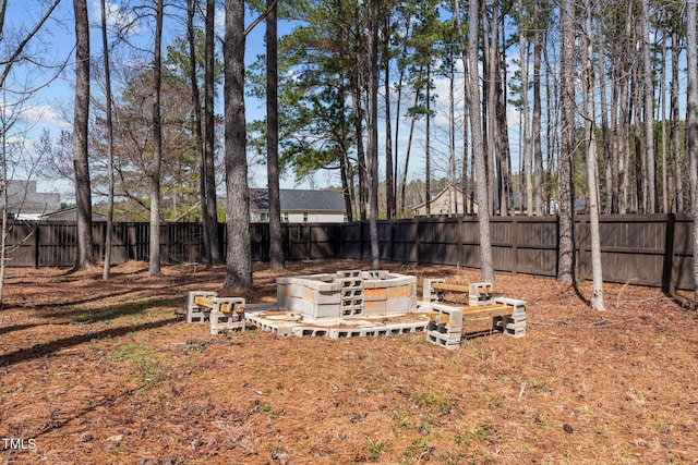 view of yard with a fenced backyard and a fire pit