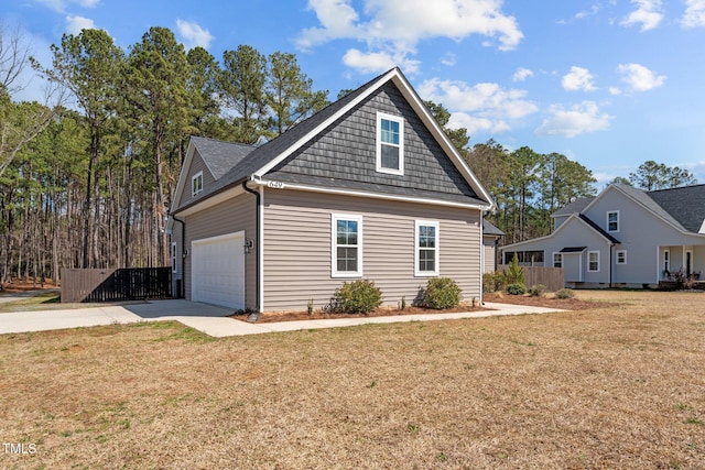 view of front of home featuring a garage, concrete driveway, fence, and a front lawn