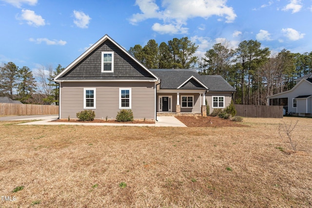 view of front facade featuring a front yard and fence