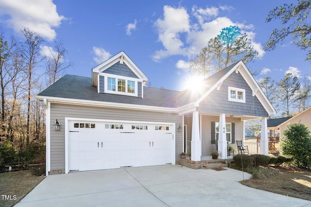 view of front of home with a porch, driveway, and an attached garage