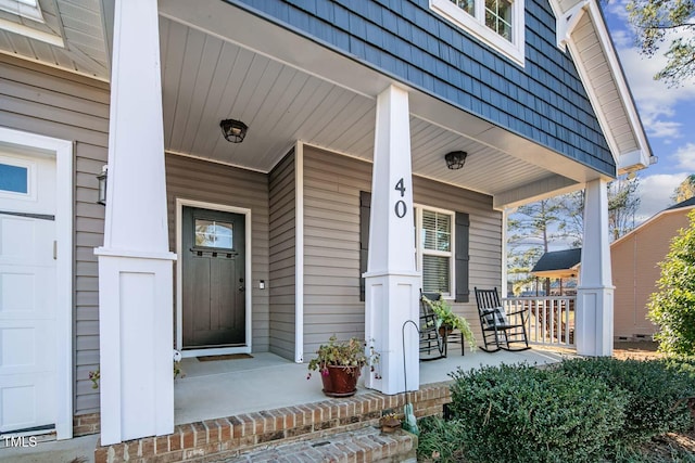 doorway to property featuring mansard roof and a porch