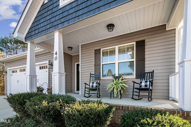 entrance to property featuring a garage, covered porch, and mansard roof