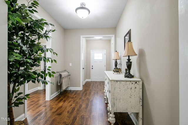 entryway with dark wood-type flooring and baseboards