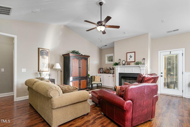 living area with vaulted ceiling, visible vents, dark wood finished floors, and a fireplace