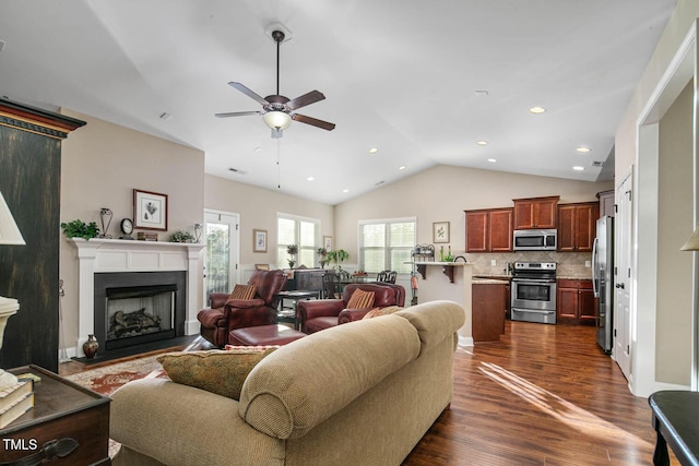 living room with dark wood-style floors, a fireplace, lofted ceiling, recessed lighting, and ceiling fan