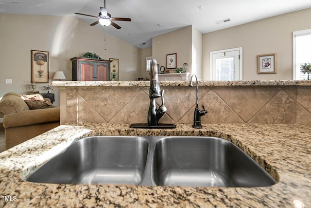 details featuring light stone countertops, ceiling fan, visible vents, and a sink