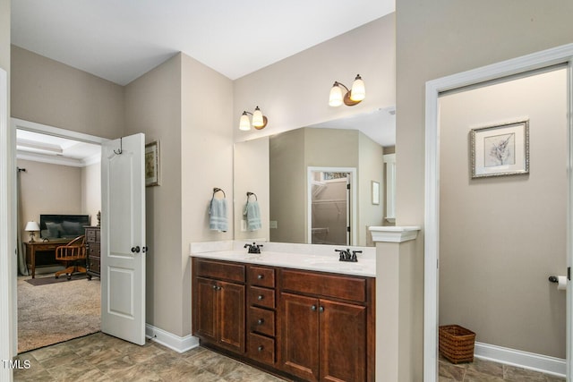 bathroom featuring a sink, baseboards, and double vanity