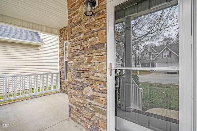 view of exterior entry featuring a porch and stone siding