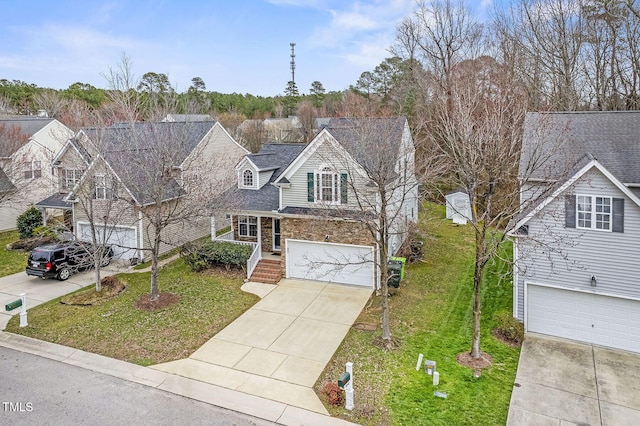 traditional-style house with stone siding, concrete driveway, a front yard, and a garage