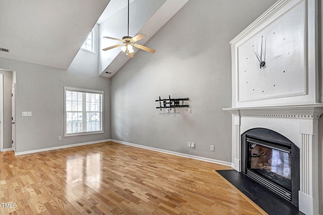 unfurnished living room with visible vents, a fireplace with flush hearth, baseboards, and light wood finished floors