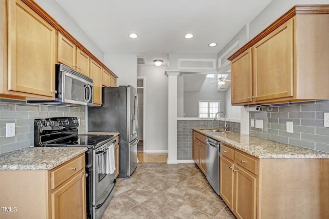 kitchen with visible vents, light stone countertops, appliances with stainless steel finishes, a ceiling fan, and a sink