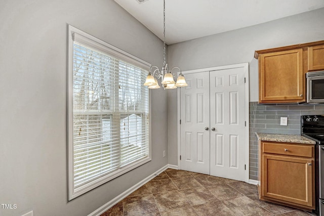 kitchen featuring decorative backsplash, a notable chandelier, plenty of natural light, and appliances with stainless steel finishes