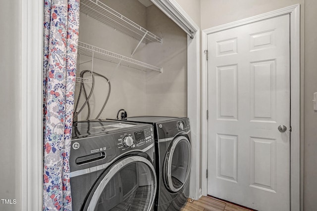 laundry room featuring laundry area, washer and dryer, and light wood-style flooring