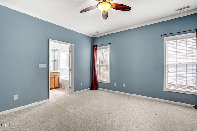 unfurnished bedroom with visible vents, light colored carpet, crown molding, and baseboards