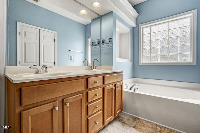 bathroom with a sink, a garden tub, recessed lighting, and double vanity