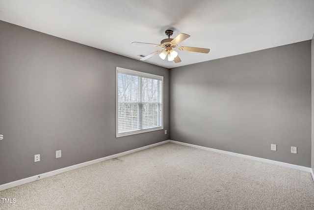 empty room featuring a ceiling fan, carpet, and baseboards