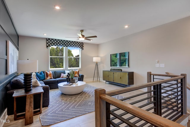 living room featuring ceiling fan, baseboards, wood finished floors, and recessed lighting