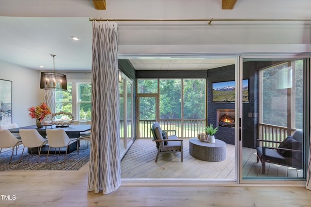 sunroom / solarium featuring a warm lit fireplace