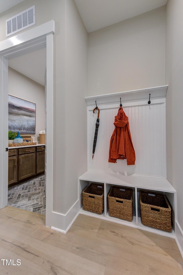 mudroom with light wood finished floors, visible vents, and baseboards