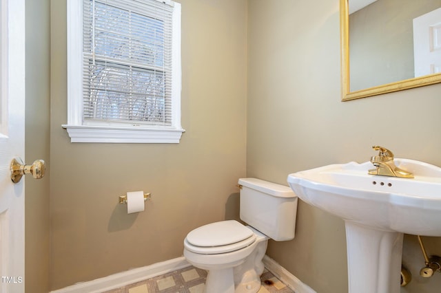 bathroom featuring baseboards and toilet