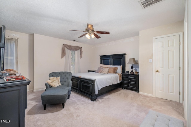 bedroom with baseboards, a ceiling fan, visible vents, and light colored carpet