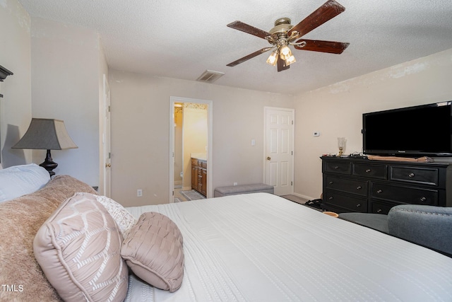 bedroom featuring a textured ceiling, visible vents, baseboards, a ceiling fan, and ensuite bath