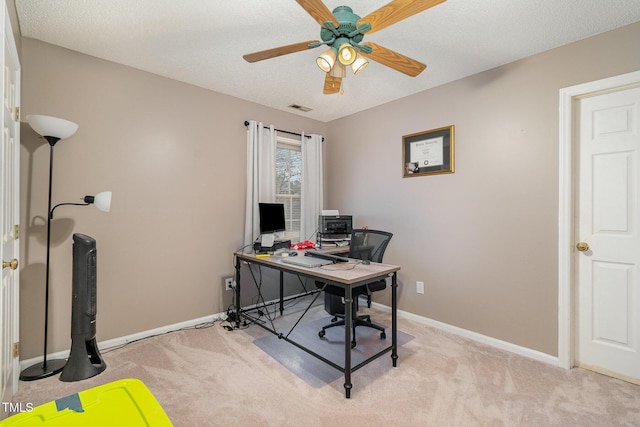 office area with visible vents, baseboards, a ceiling fan, and light colored carpet