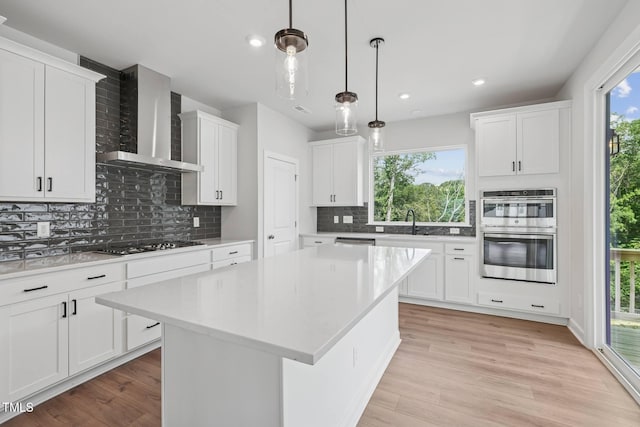 4706 Cypress Tree Ln, Raleigh, NC 27612 - kitchen featuring wall chimney range hood, double oven, a sink, black stovetop, and light countertops