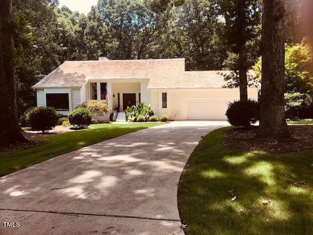 view of front of property with a garage, driveway, and a front lawn